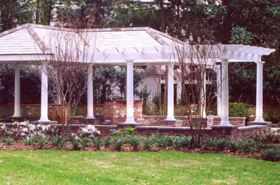 White outdoor pavilion and covered patio in a landscaped yard
