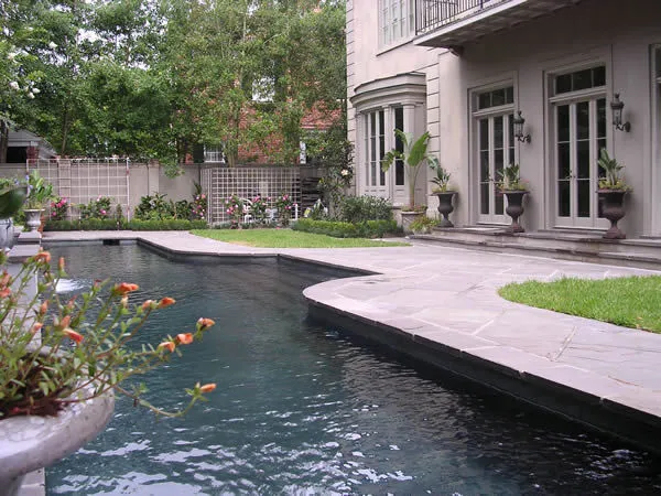 Custom swimming pool and patio beside a custom-built home