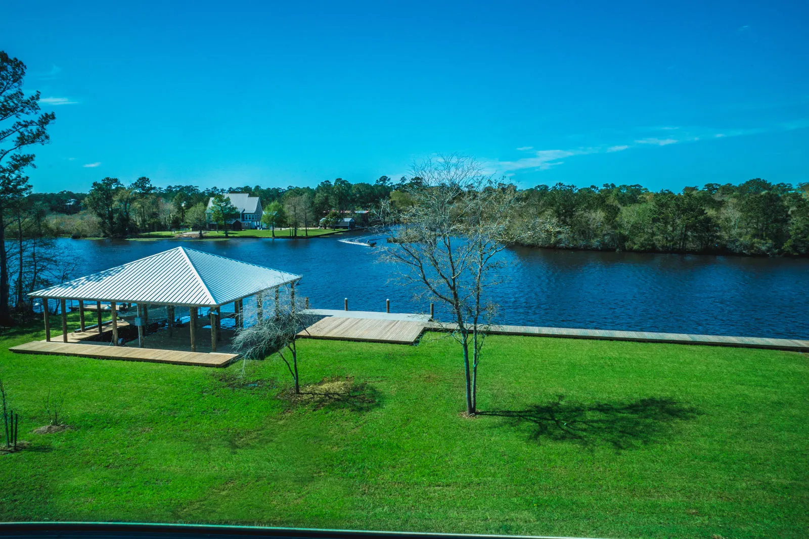 Waterfront property with lawn, pond, and covered dock structure